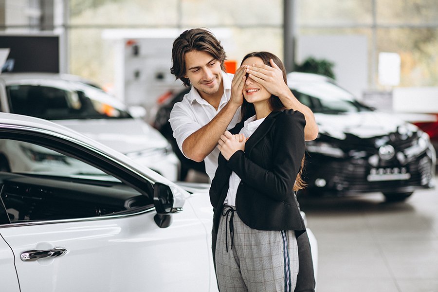 Man Making A Present For His Woman In A Car Showroom Imagen de Man Making A Present For His Woman In A Car Showroom
